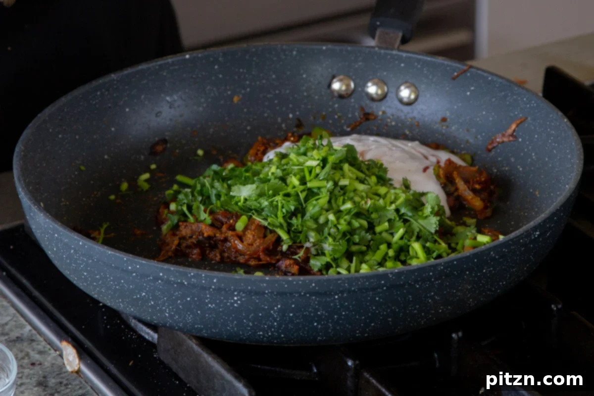 South Indian Black Pepper Tofu Fry 17 Adding non-dairy yogurt and cilantro stems to the spiced onion mixture in the pan