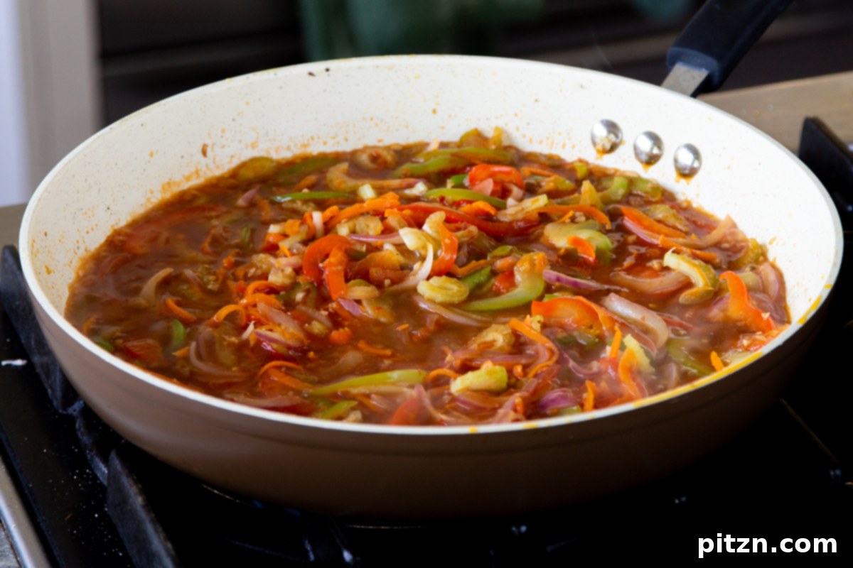 One Pan 30 Minute Schezwan Tofu 13 Veggies beautifully coated in the rich Szechuan sauce in the pan.