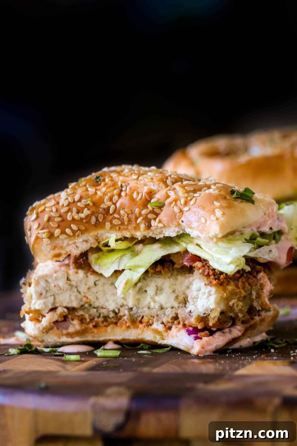 The Inclusive Crispy Vegan Chicken Sandwich 3 close-up of a vegan chicken sandwich with a bite taken out