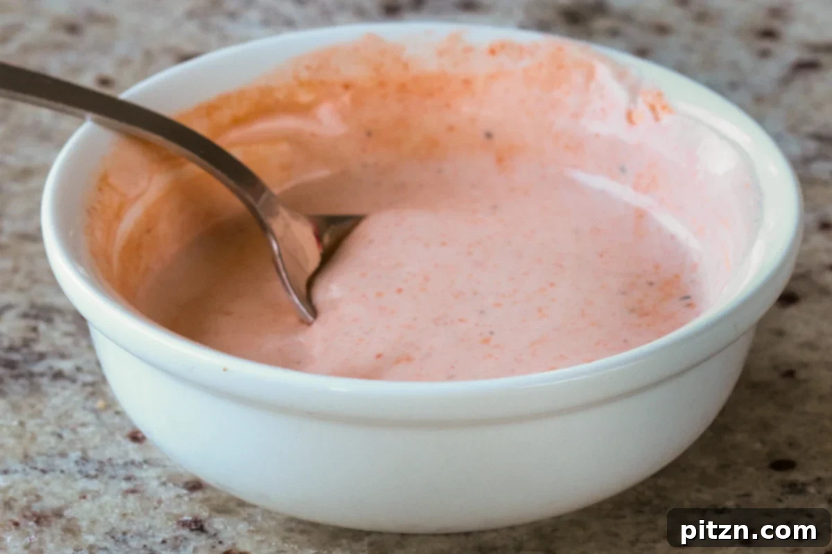 The Inclusive Crispy Vegan Chicken Sandwich 20 bowl of spicy mayo with a spoon in it