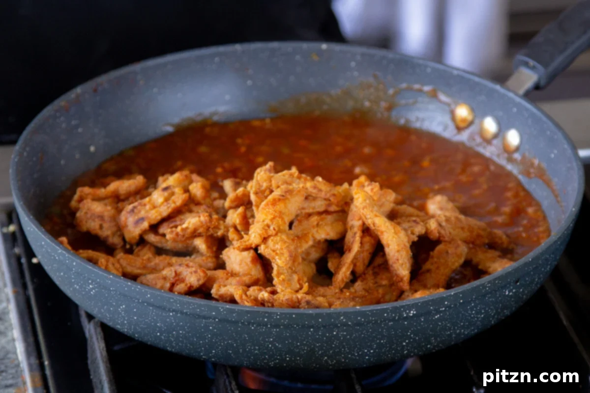 Zesty Indo Chinese Crispy Chicken and Soy Curls Nut Free Gluten Free Soy Free Adaptable 21 adding soy curls to the pan of sauce