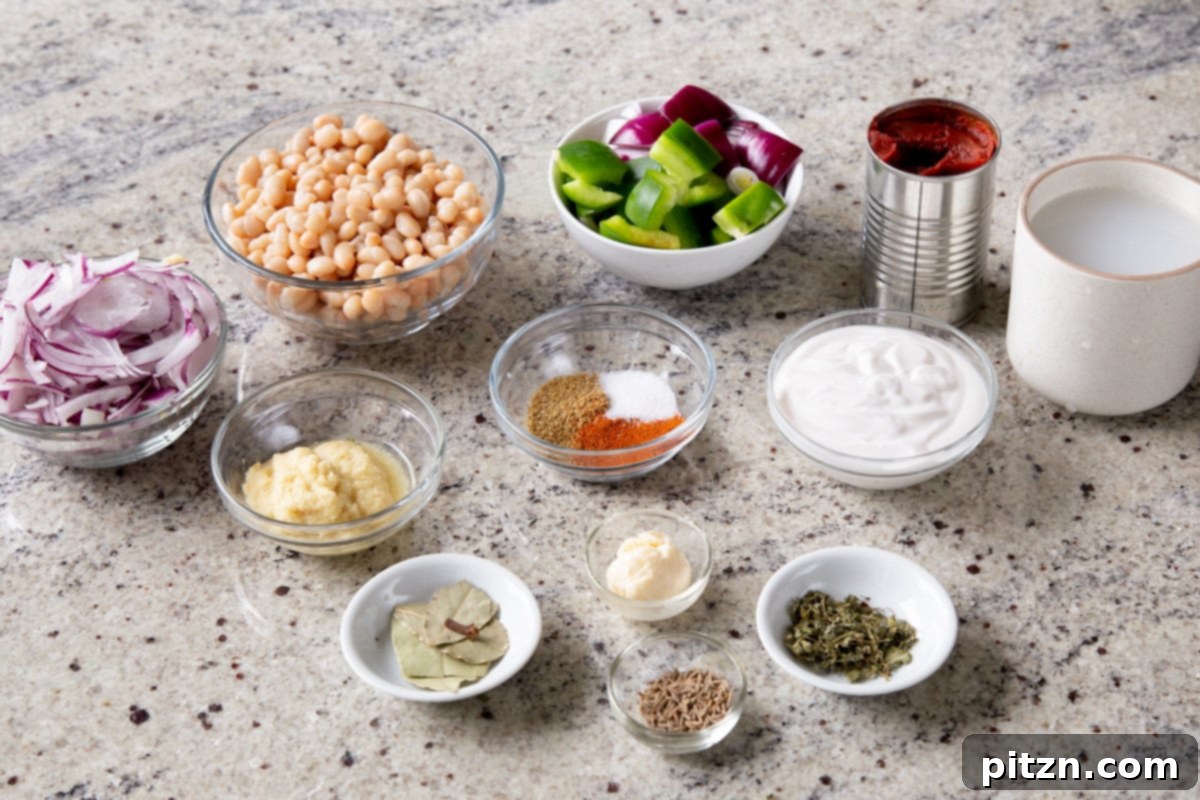 One Pot White Bean Do Pyaza Curry 6 Assortment of fresh ingredients for Beans Do Pyaza, including beans, onions, and spices, laid out on a kitchen counter