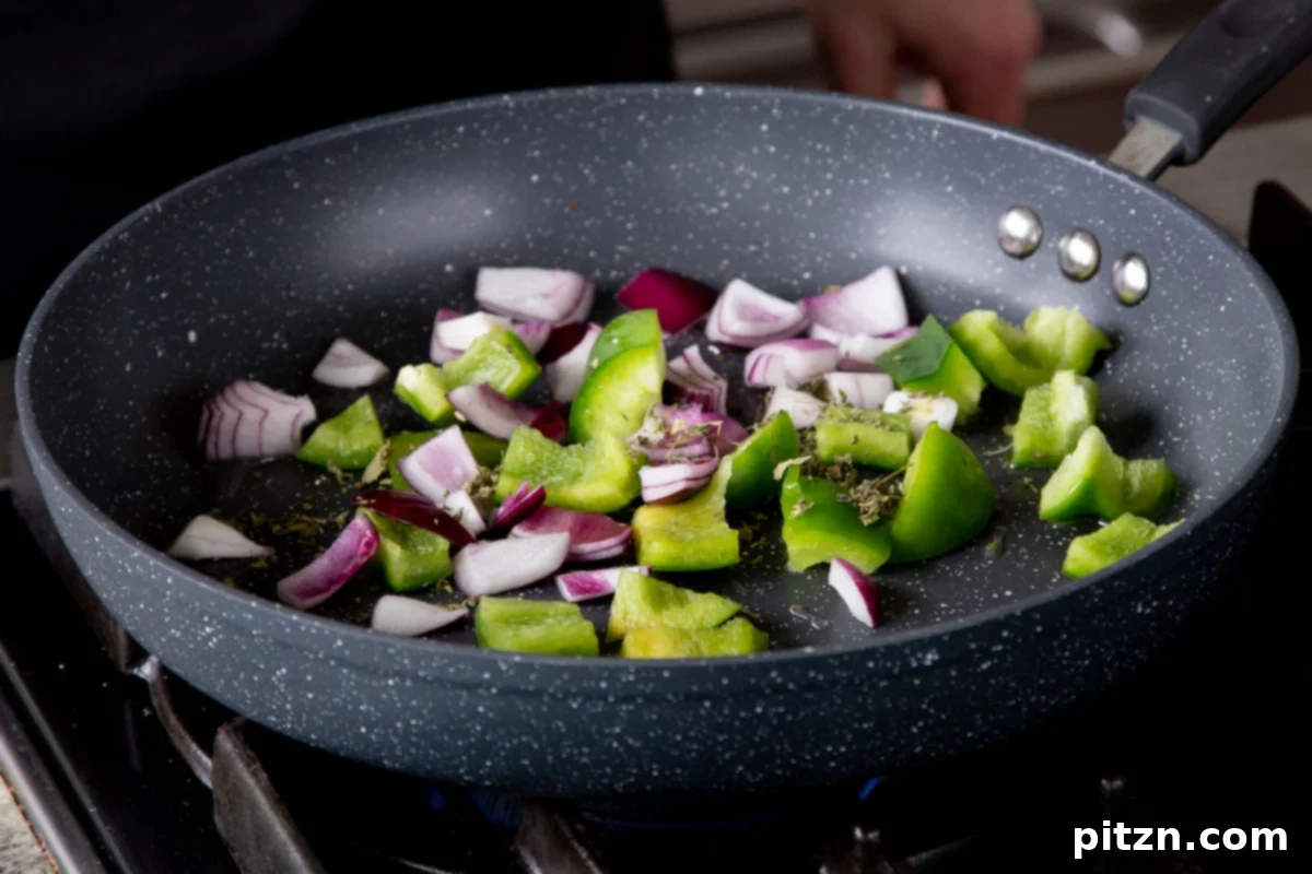 One Pot White Bean Do Pyaza Curry 7 Cooking the vibrant green peppers and red onions in a hot pan for the garnish, showing them starting to char at the edges.