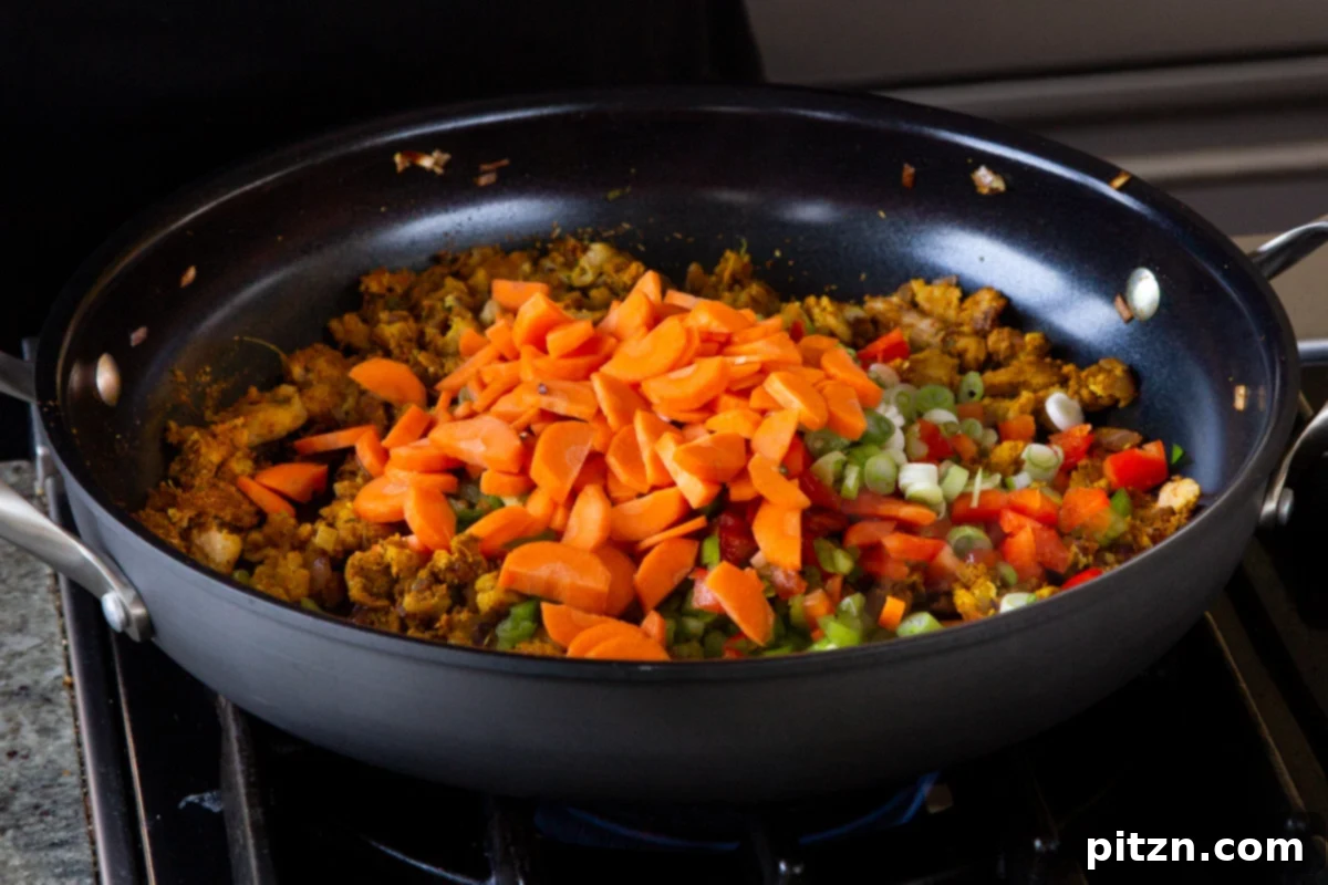 Simple One Pot Jamaican Curry Rice Gluten Free Nut Free 11 Tender chopped carrots being added to the simmering curry base in the skillet, contributing sweetness and color.