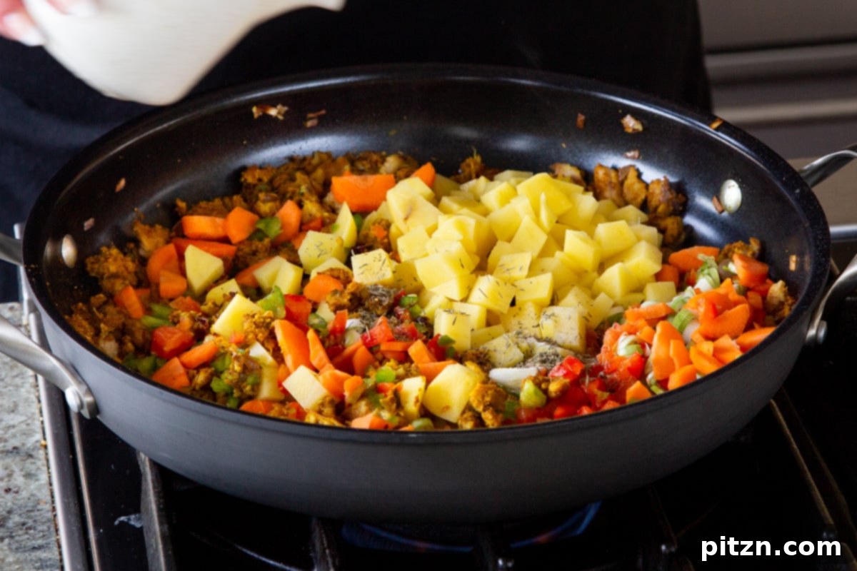 Simple One Pot Jamaican Curry Rice Gluten Free Nut Free 12 Cubed potatoes and a splash of water are added to the skillet with other vegetables, preparing for simmering.