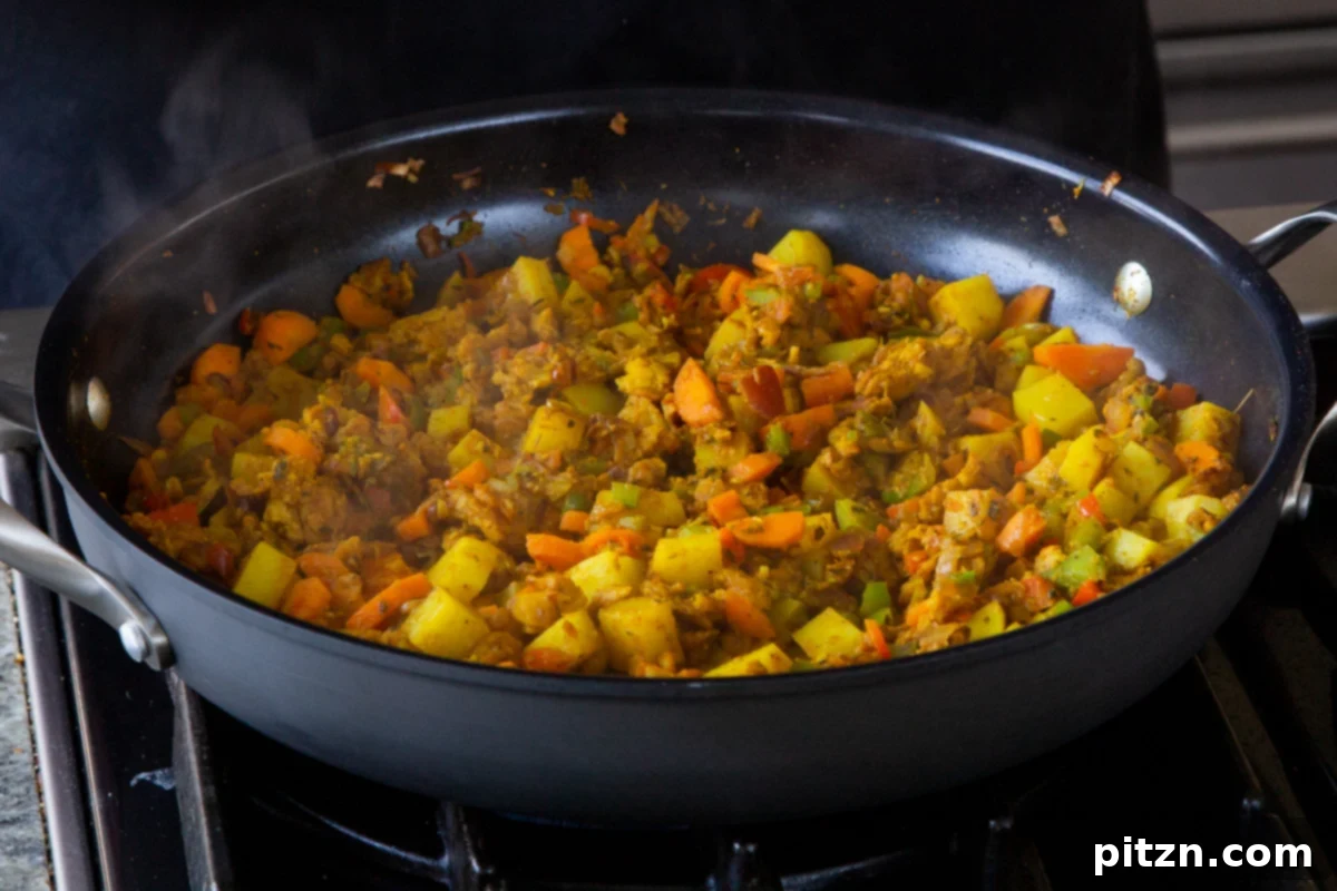 Simple One Pot Jamaican Curry Rice Gluten Free Nut Free 13 A mix of vibrant vegetables simmering in the pan, covered, until the potatoes are al dente and flavors have melded.