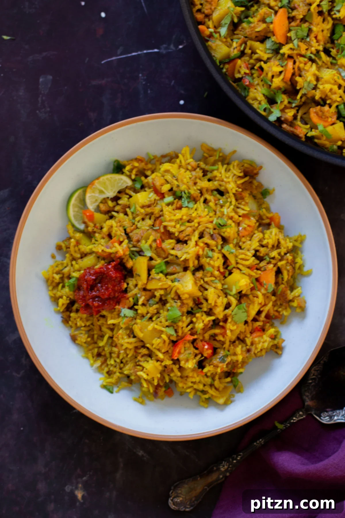 Simple One Pot Jamaican Curry Rice Gluten Free Nut Free 3 A beautifully plated bowl of Vegan Jamaican Curry Rice, served with a side of hot sauce and a fresh lime wedge, ready to enjoy.