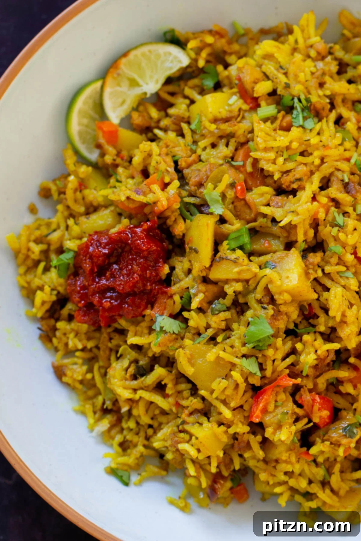 Simple One Pot Jamaican Curry Rice Gluten Free Nut Free 4 A close-up view of the rich, golden Vegan Jamaican Curry Rice in a white bowl, showcasing the tender soy curls, vibrant vegetables, and fluffy rice.