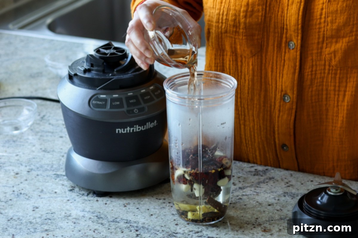 adding balchao paste ingredients to the blender