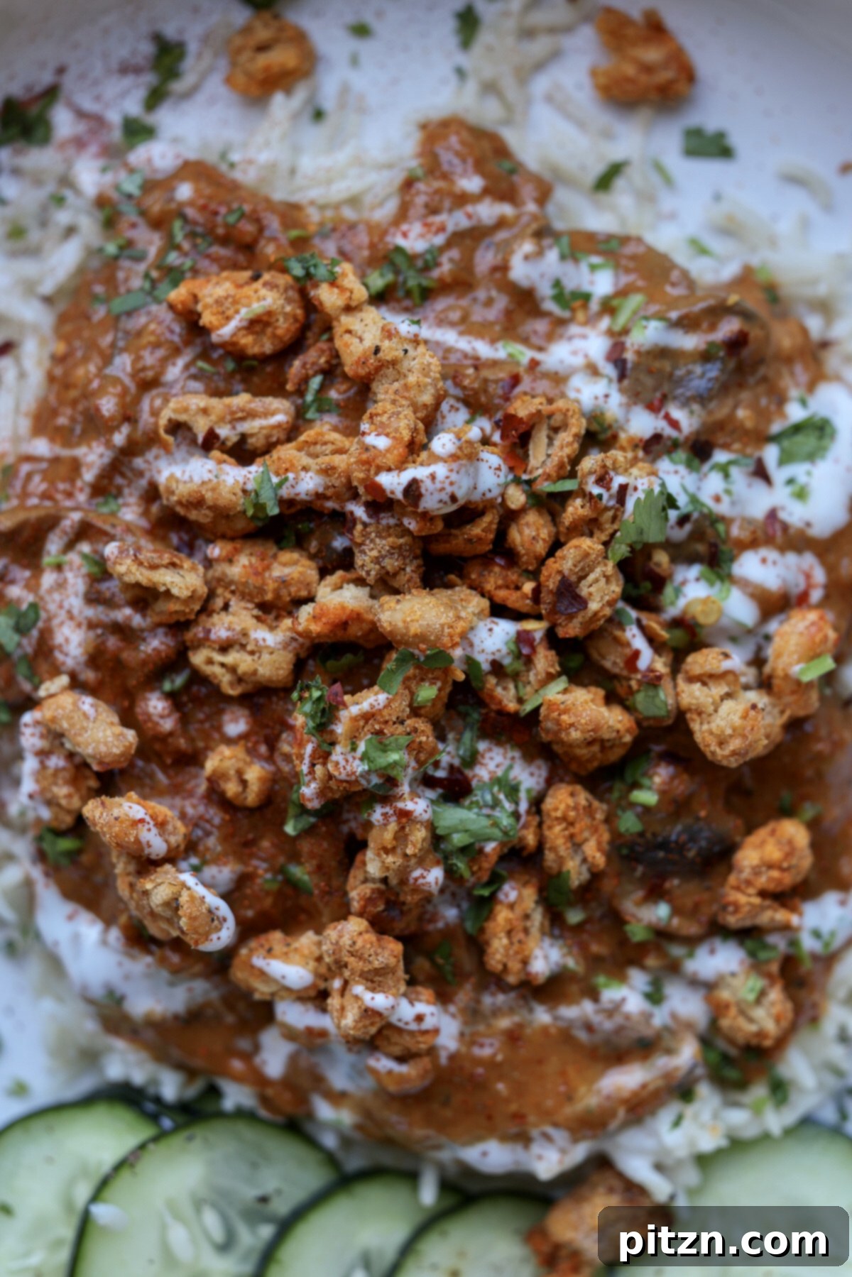 close-up of a bowl of balchao mushrooms topped with crispy beans and non-dairy yogurt