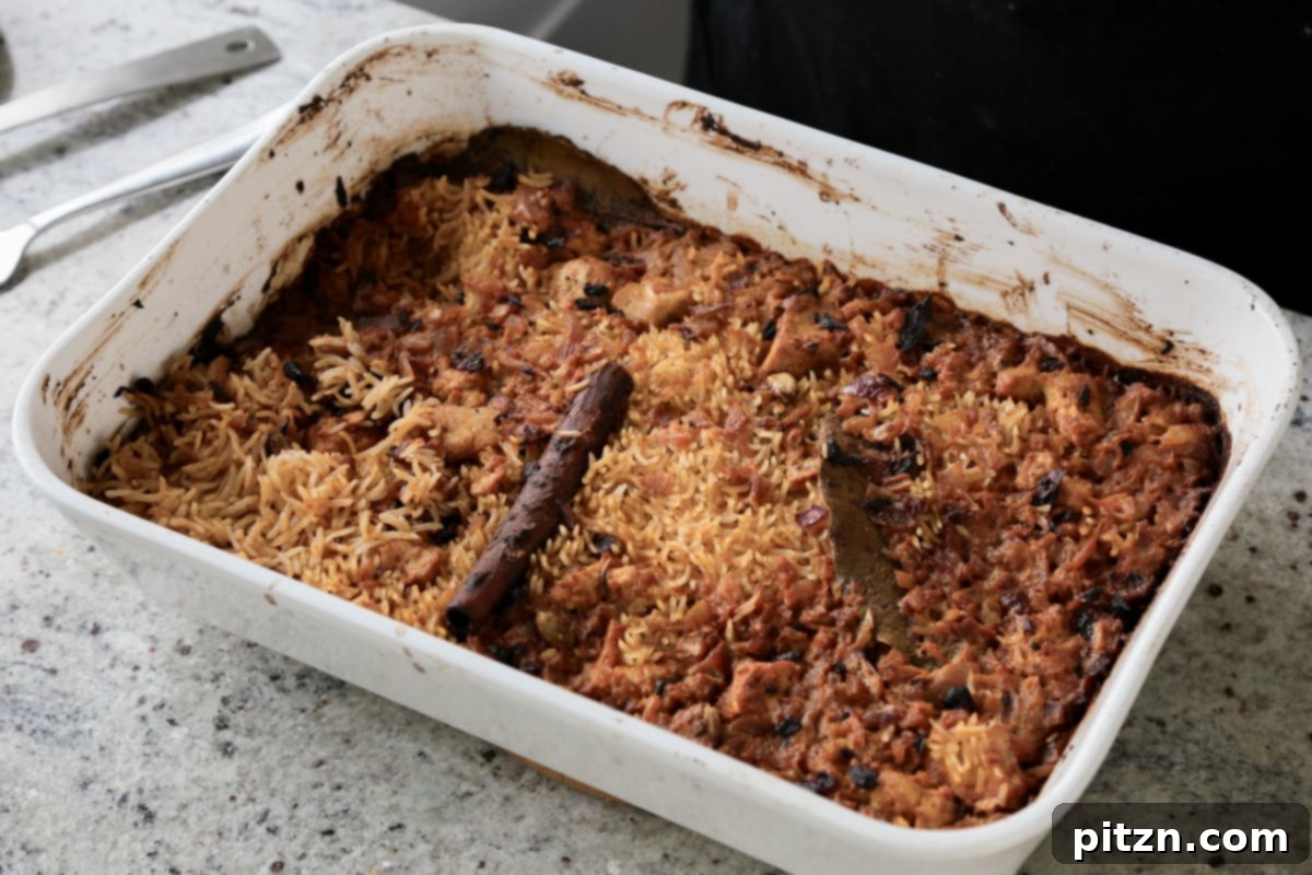 The Lucknowi Biryani, fresh from the oven, showcasing perfectly cooked rice and tofu in the baking pan, steam gently rising.