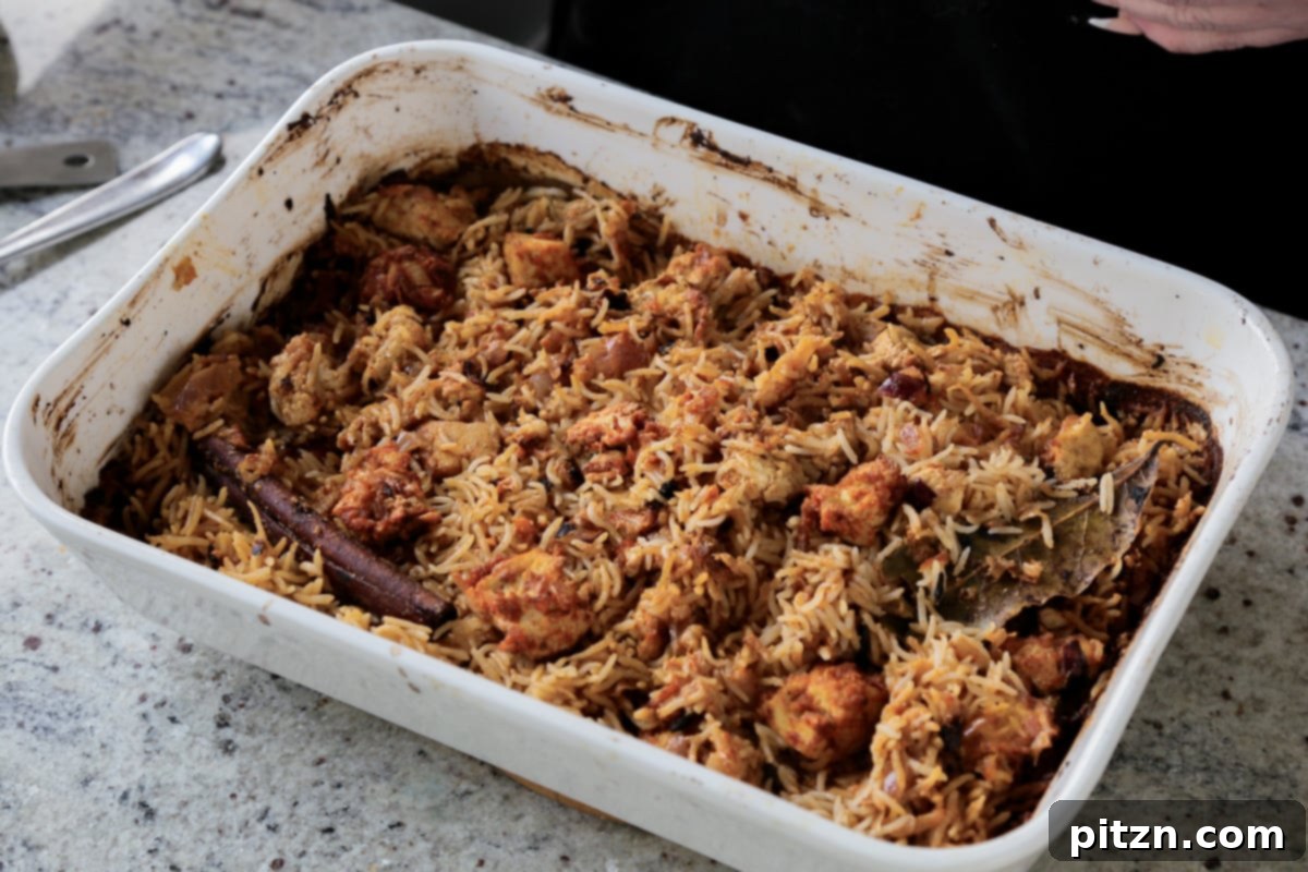 Fluffed Lucknowi Biryani in the baking pan, showing the distinct grains of rice and spiced tofu, ready for serving.