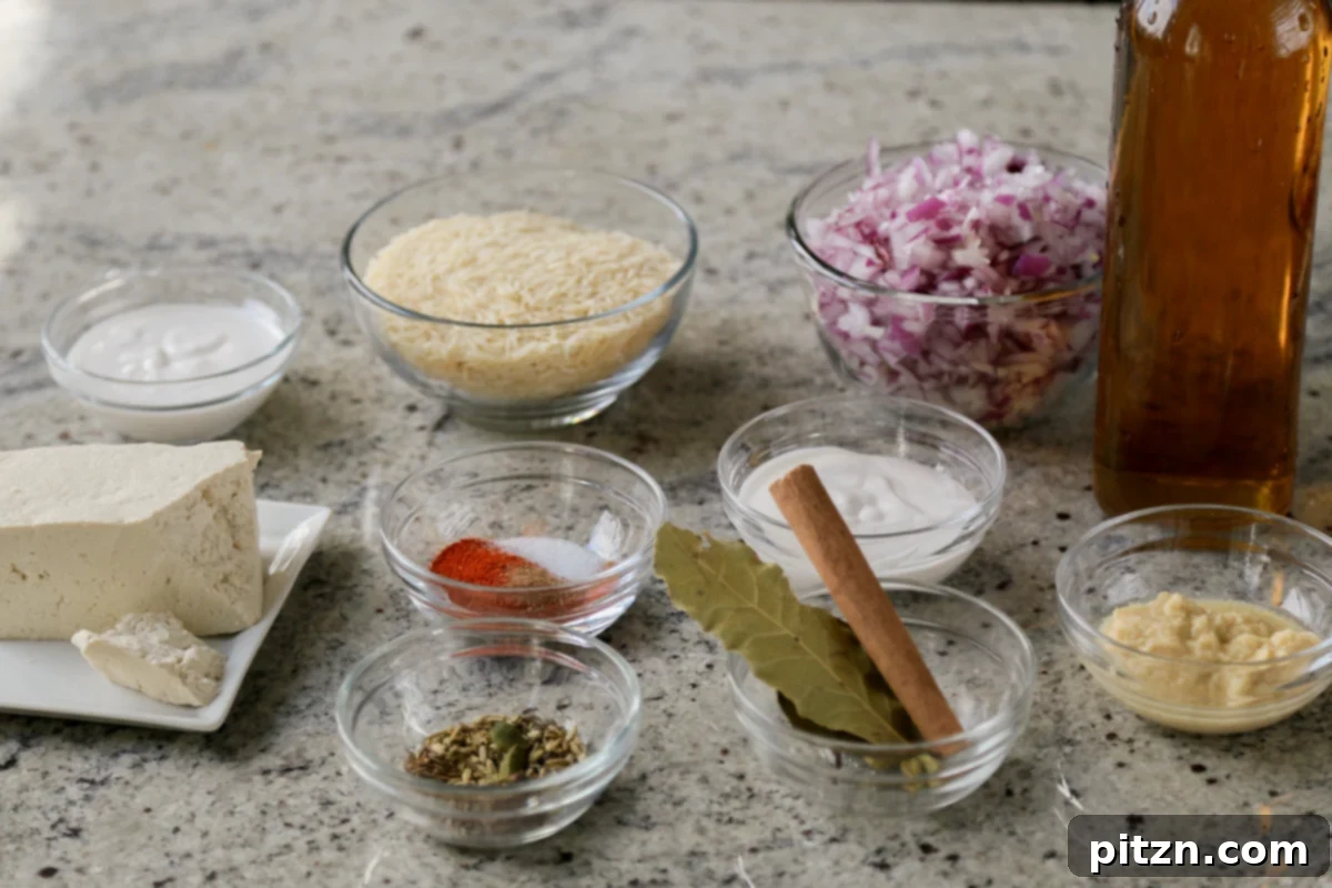 Bowls filled with individual biryani ingredients including rice, various whole spices, and aromatics laid out on a kitchen counter, ready for preparation.