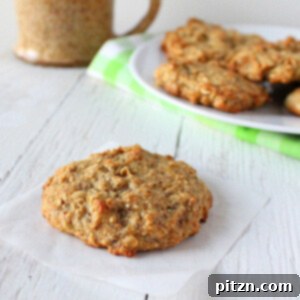 A freshly baked banana oatmeal quinoa raisin muffin top cookie on parchment paper, ready to cool.