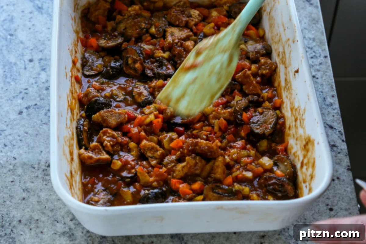 mushrooms, tofu, and peppers tossed in the sauce before baking