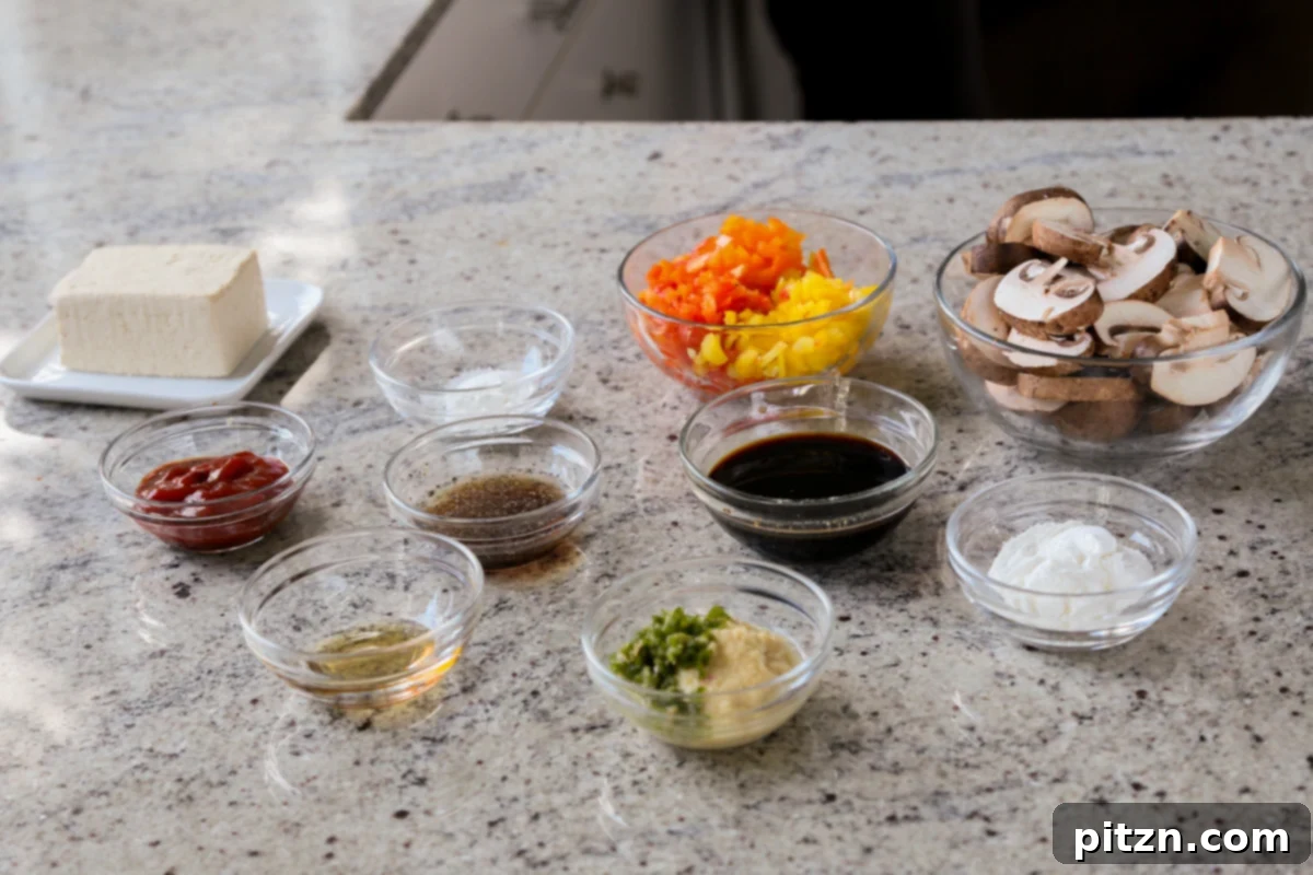 mushrooms, tofu, and other baked stir fry ingredients in bowls on a kitchen counter
