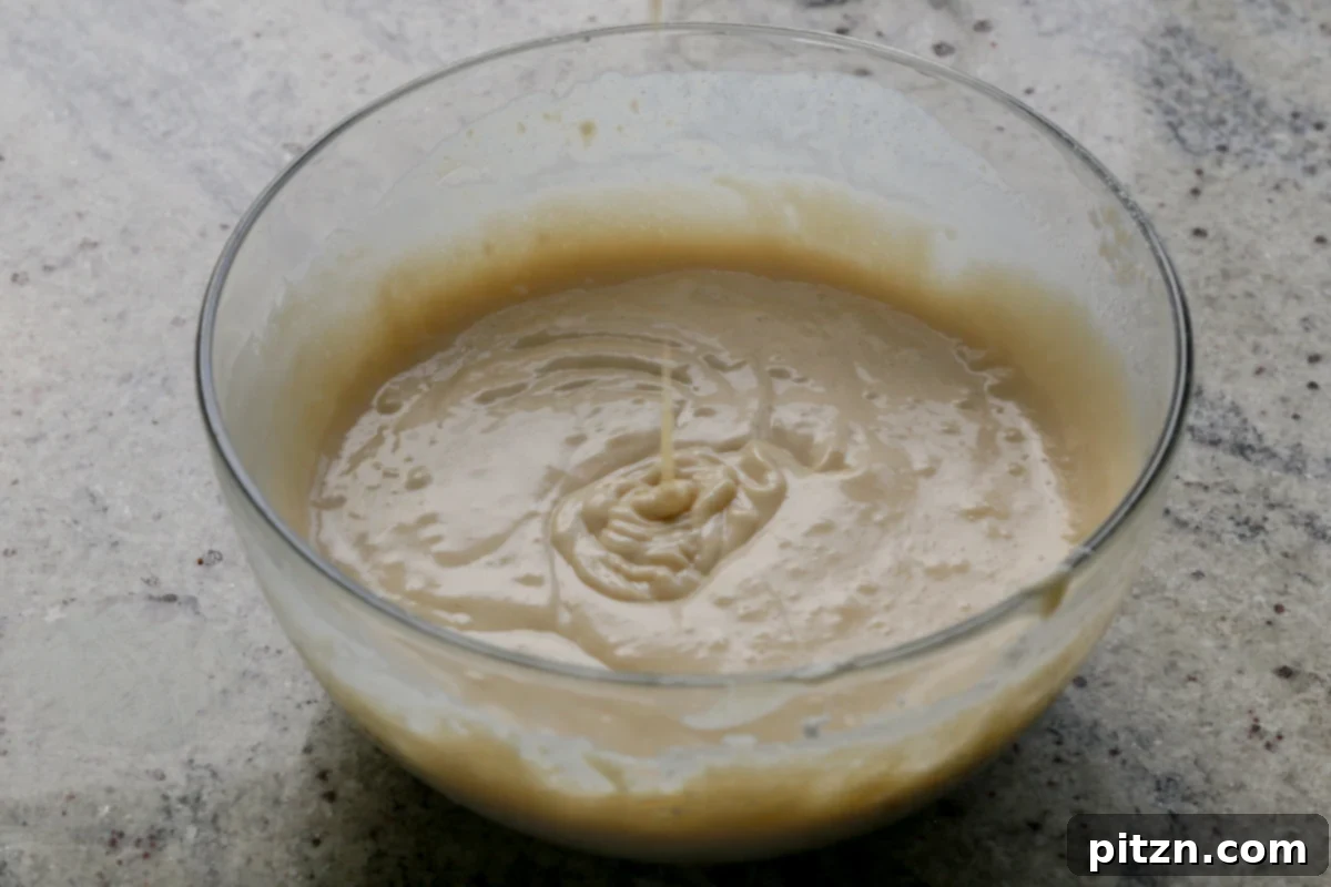 Zesty Vegan Lemon Cloud Cake 13 Smooth vegan lemon cake batter in a mixing bowl after all ingredients are combined