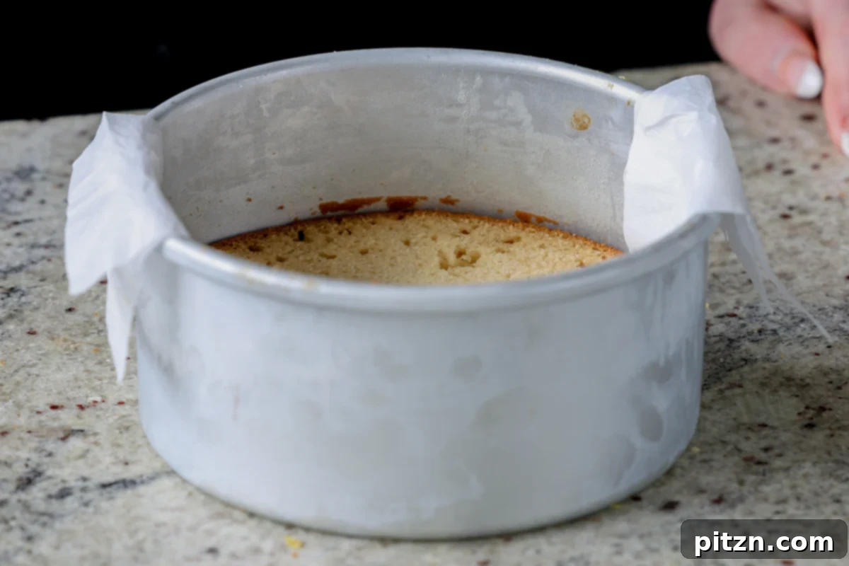 Zesty Vegan Lemon Cloud Cake 20 The first cake layer placed securely in a parchment-lined pan, ready for frosting