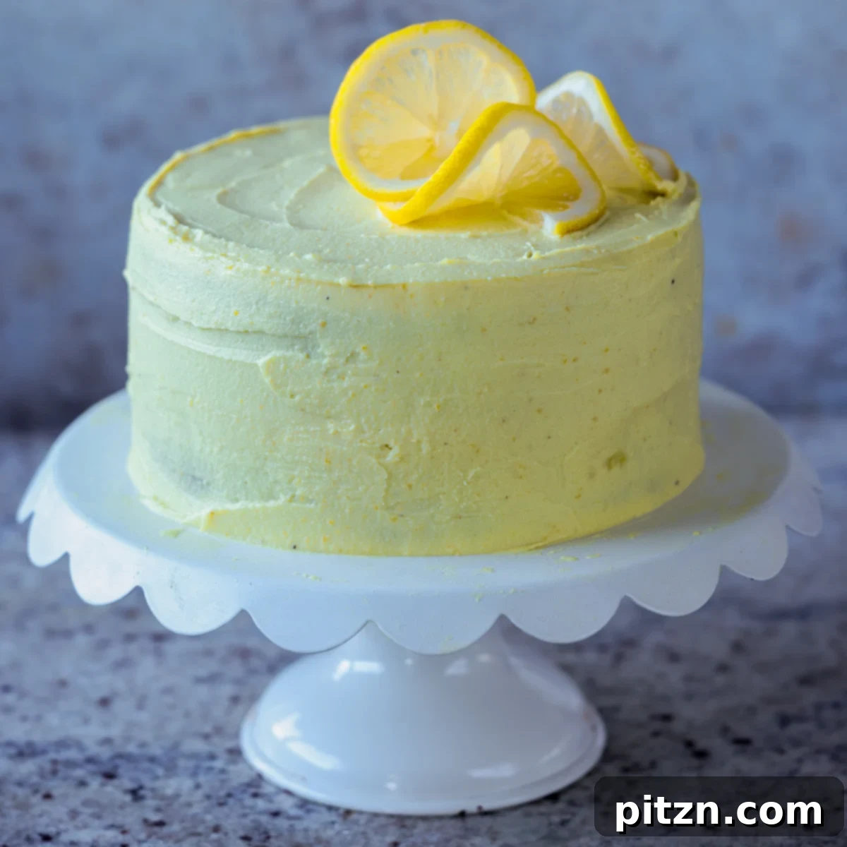 Zesty Vegan Lemon Cloud Cake 27 A stunning vegan lemon cake on a serving tray, expertly frosted and garnished with fresh lemon slices