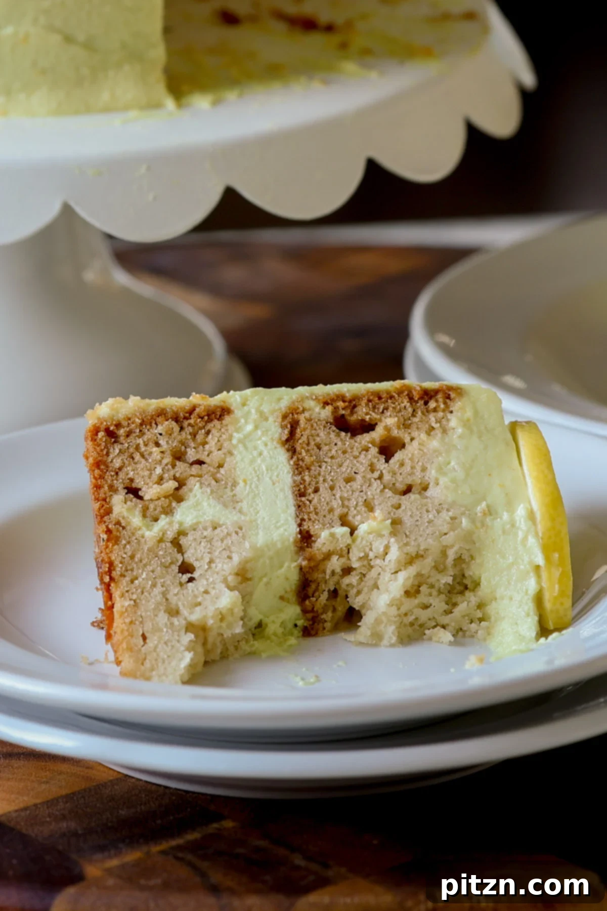 Zesty Vegan Lemon Cloud Cake 6 A half-eaten slice of vegan lemon cake, showing the fluffy cake and creamy frosting layers