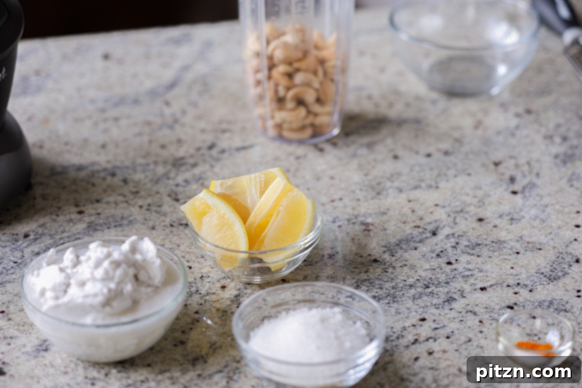 Zesty Vegan Lemon Cloud Cake 9 Ingredients for vegan lemon frosting laid out in bowls on a kitchen counter, featuring cashews and coconut cream