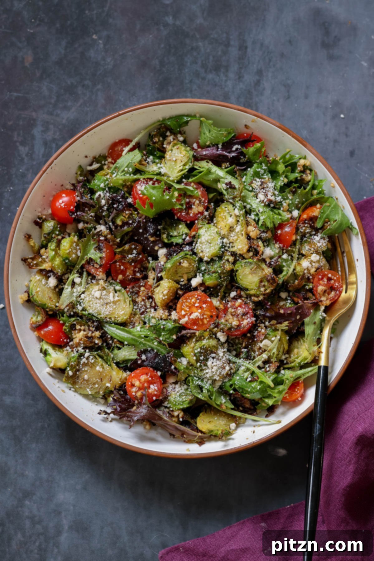 Roasted Shaved Brussels Salad with Walnut Crumble 2 shaved Brussels sprouts salad in a bowl with tomatoes, lettuce, and walnut crumble