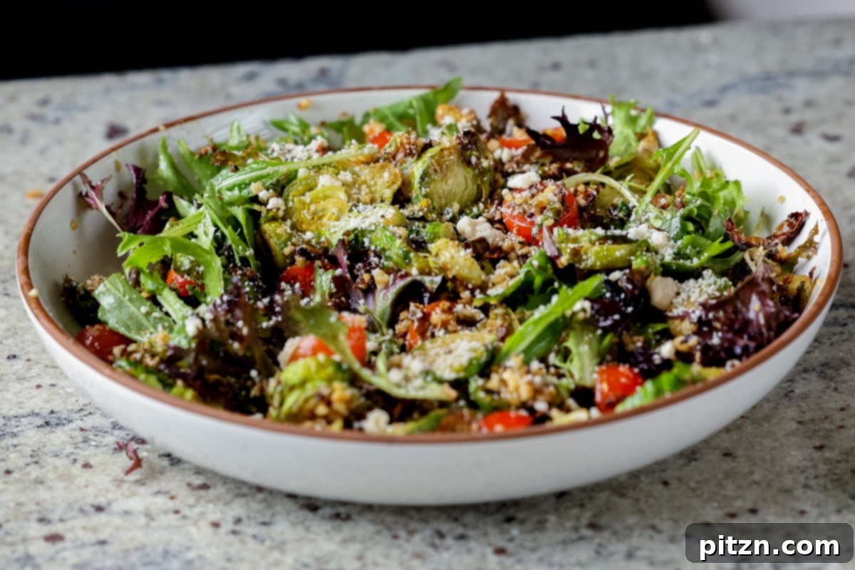 Roasted Shaved Brussels Salad with Walnut Crumble 17 shaved Brussels sprouts salad in a bowl with tomatoes, lettuce, and walnut crumble