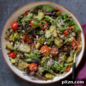 Roasted Shaved Brussels Salad with Walnut Crumble 6 shaved Brussels sprouts salad in a bowl with tomatoes, lettuce, and walnut crumble