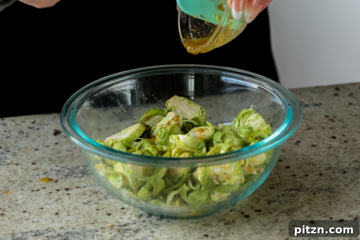 Roasted Shaved Brussels Salad with Walnut Crumble 9 pouring seasonings onto shaved Brussels sprouts in a bowl