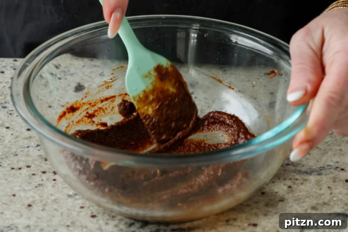 Close-up of the seasoning paste for the chorizo tofu being thoroughly mixed in a bowl, showcasing its smooth consistency and rich color.