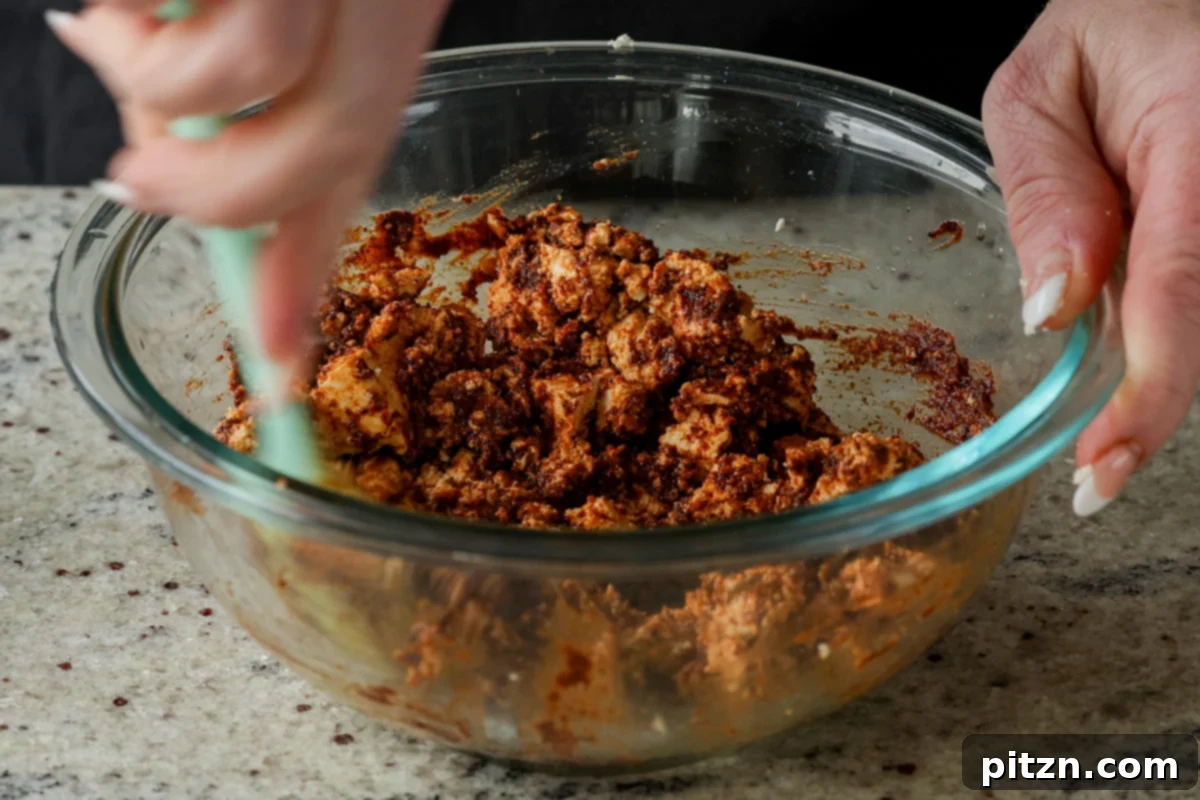 The crumbled tofu perfectly mixed into the rich seasoning paste, ready to be spread onto a baking sheet.