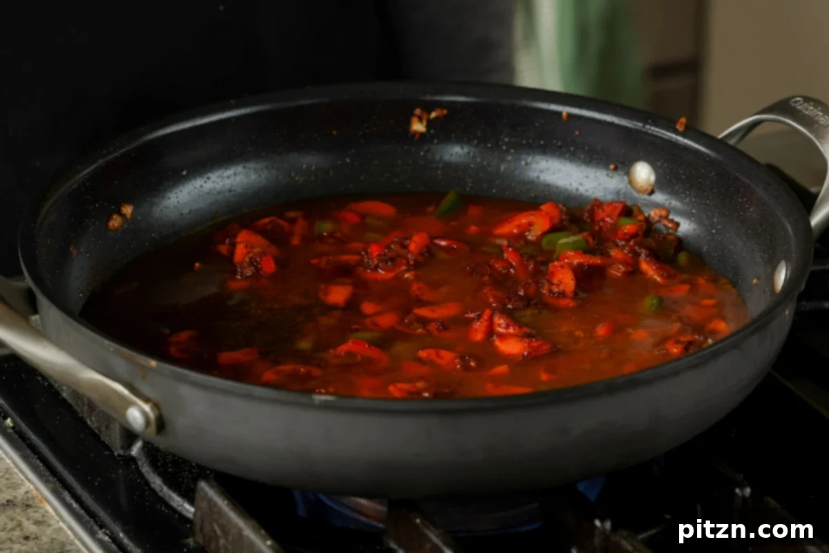 Adding water and additional spices to the vegetables in the pan, infusing the base with rich flavor.