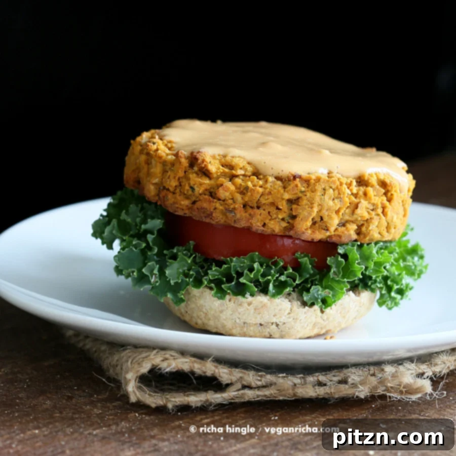 Savory Sweet Potato Peanut Vegan Burgers 4 Beautifully plated Sweet Potato Peanut Burgers with fresh greens and sauce, ready to serve.