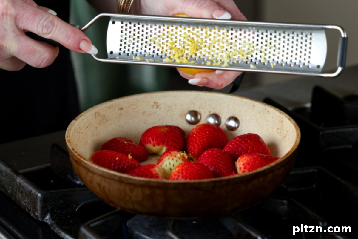 Vegan Strawberry Mousse Cake Gluten Free 14 Adding lemon zest to chopped strawberries in a pan for the compote