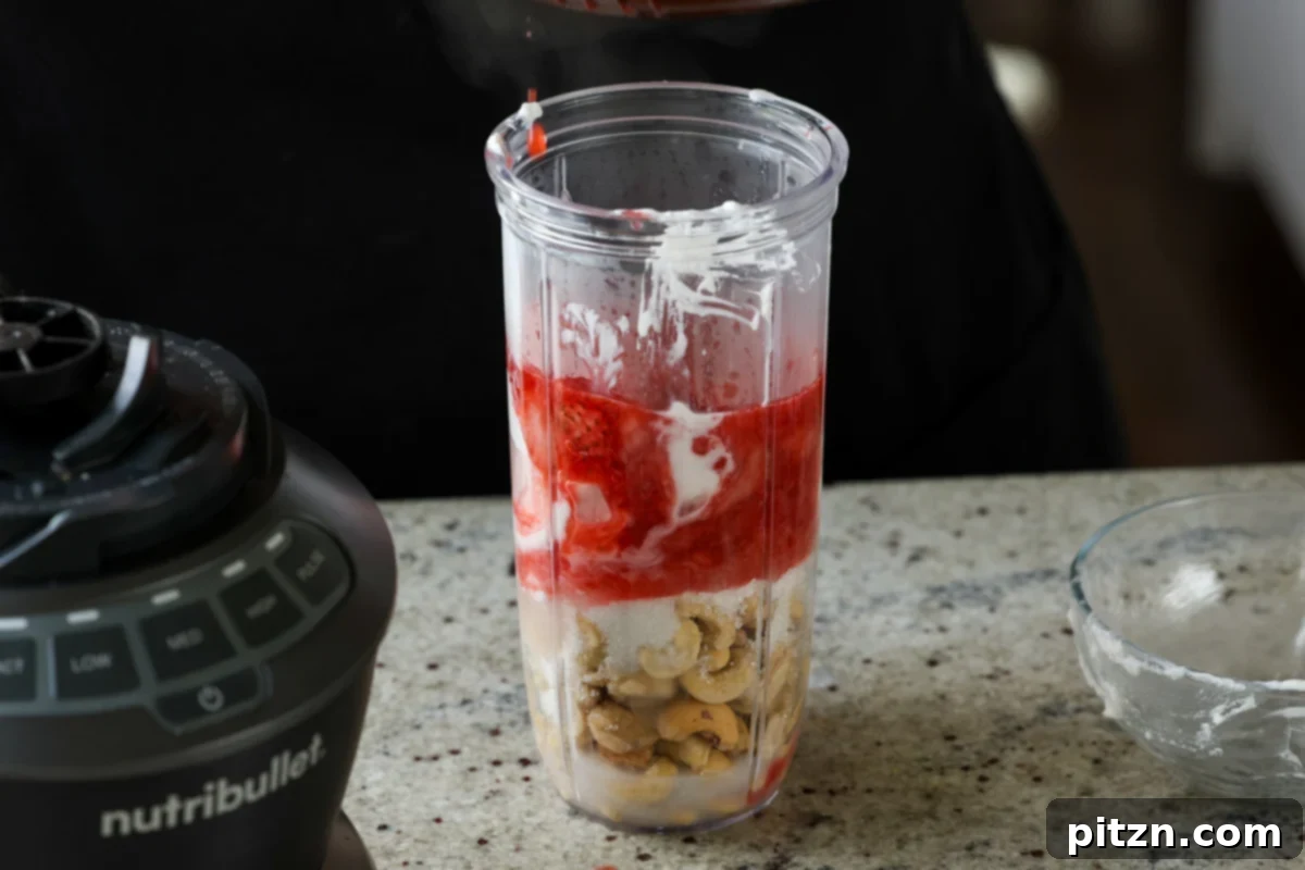 Vegan Strawberry Mousse Cake Gluten Free 19 Adding strawberry compote to the mousse ingredients in the blender
