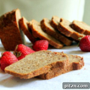 Slices of strawberry mango molasses loaf arranged with fresh strawberries
