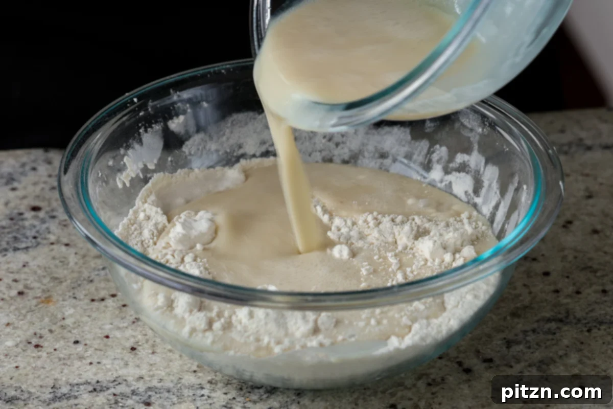 Unbelievably Fluffy Vegan Gluten-Free Chocolate Chip Muffins 10 Pouring the bowl of wet ingredients into the bowl of dry ingredients to form the muffin batter.
