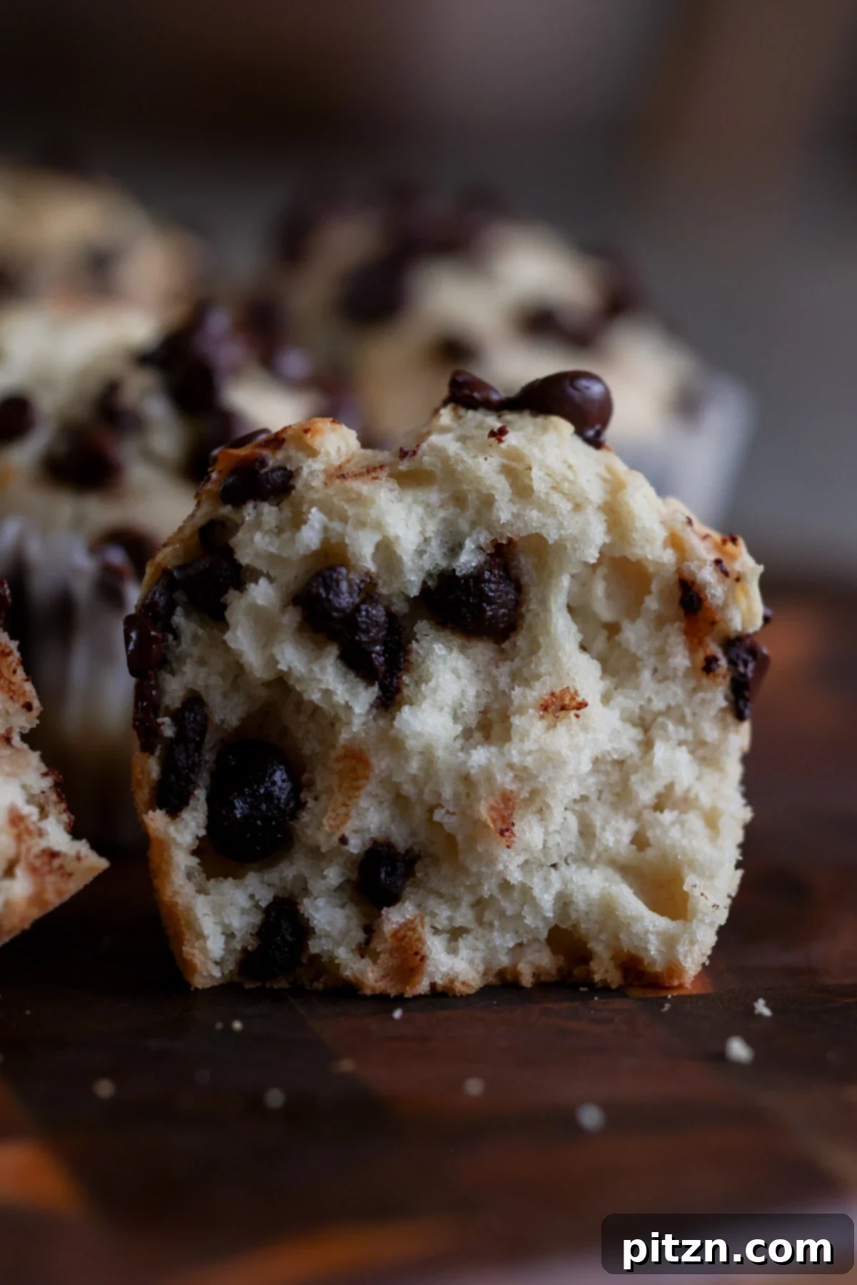 Unbelievably Fluffy Vegan Gluten-Free Chocolate Chip Muffins 5 A vegan chocolate chip muffin cut in half, revealing its moist, fluffy interior studded with melted chocolate chips.