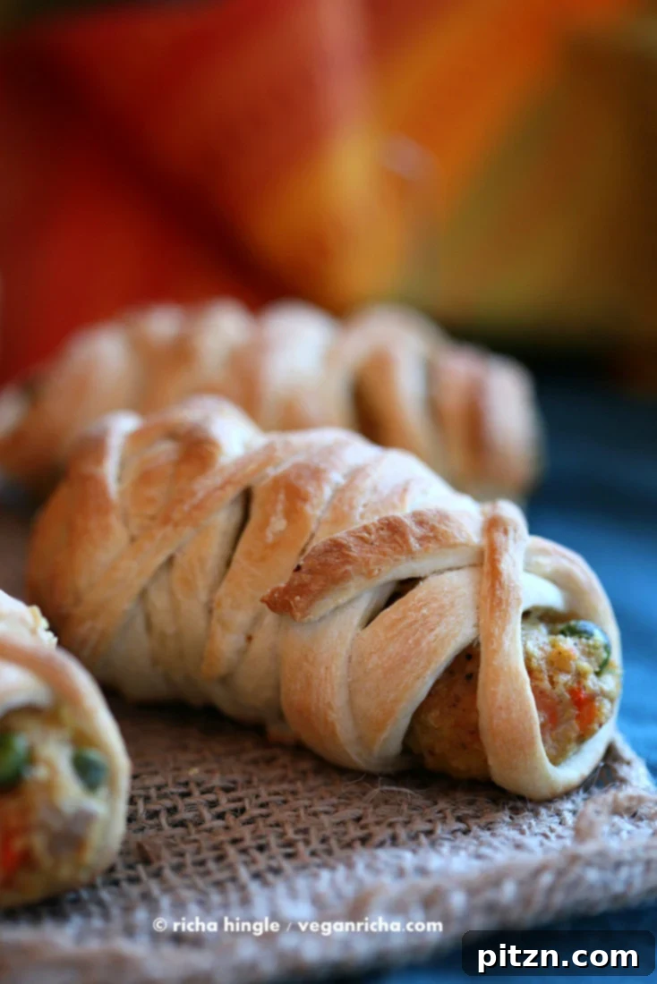 Vegan Bites Spooky Mummy Dogs and Spicy Masala Cutlets 10 Two baked Vegan Mummy Dogs with expressive olive eyes on a plate