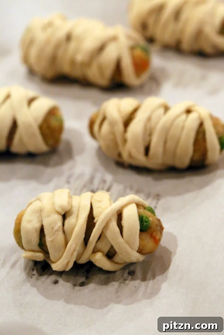 Vegan Bites Spooky Mummy Dogs and Spicy Masala Cutlets 7 Hands wrapping veggie potato cutlets with pizza dough strips