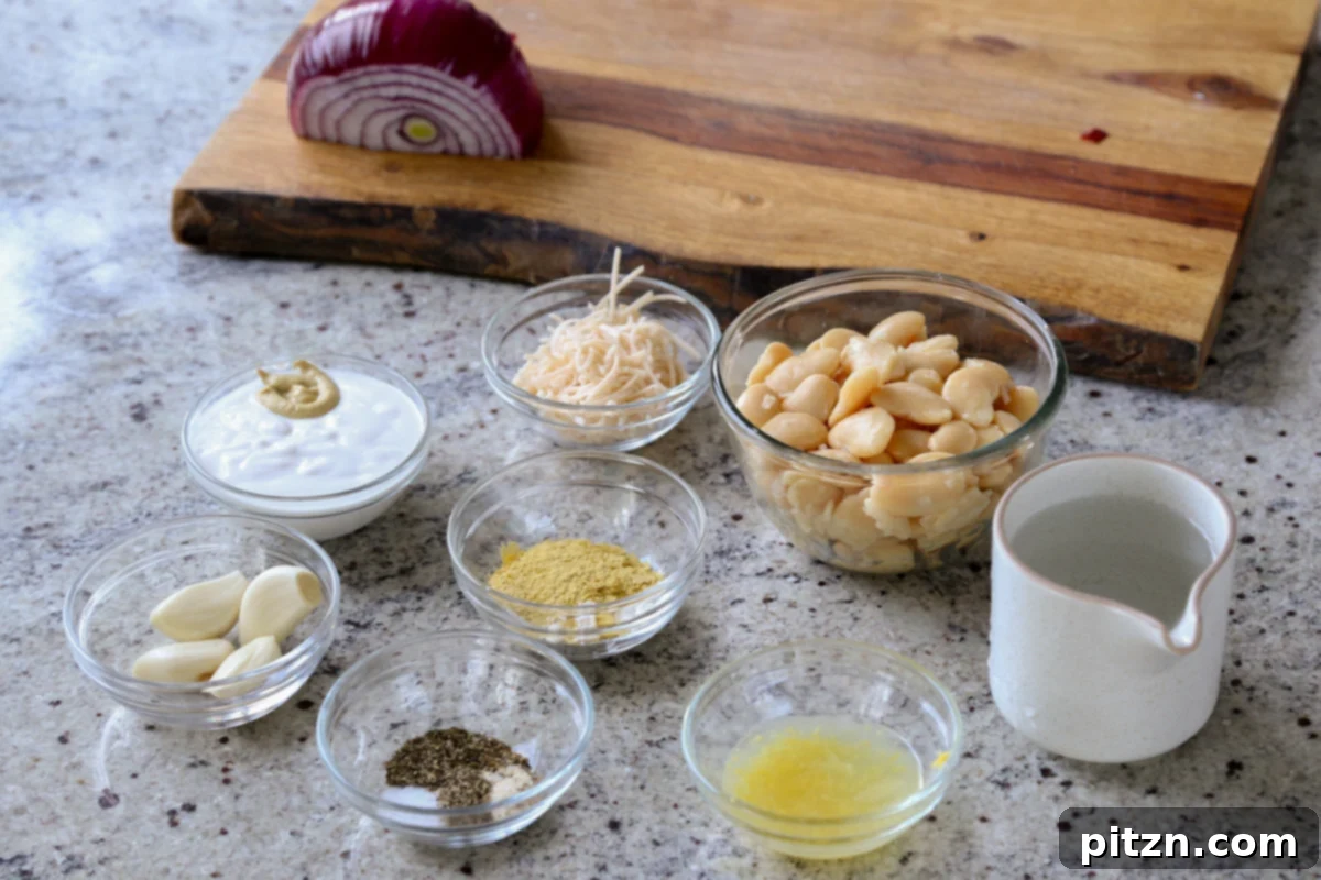 Assortment of fresh ingredients for lemon garlic butter beans laid out beautifully on a wooden kitchen counter, including fresh lemons, cloves of garlic, a can of butter beans, and various herbs.