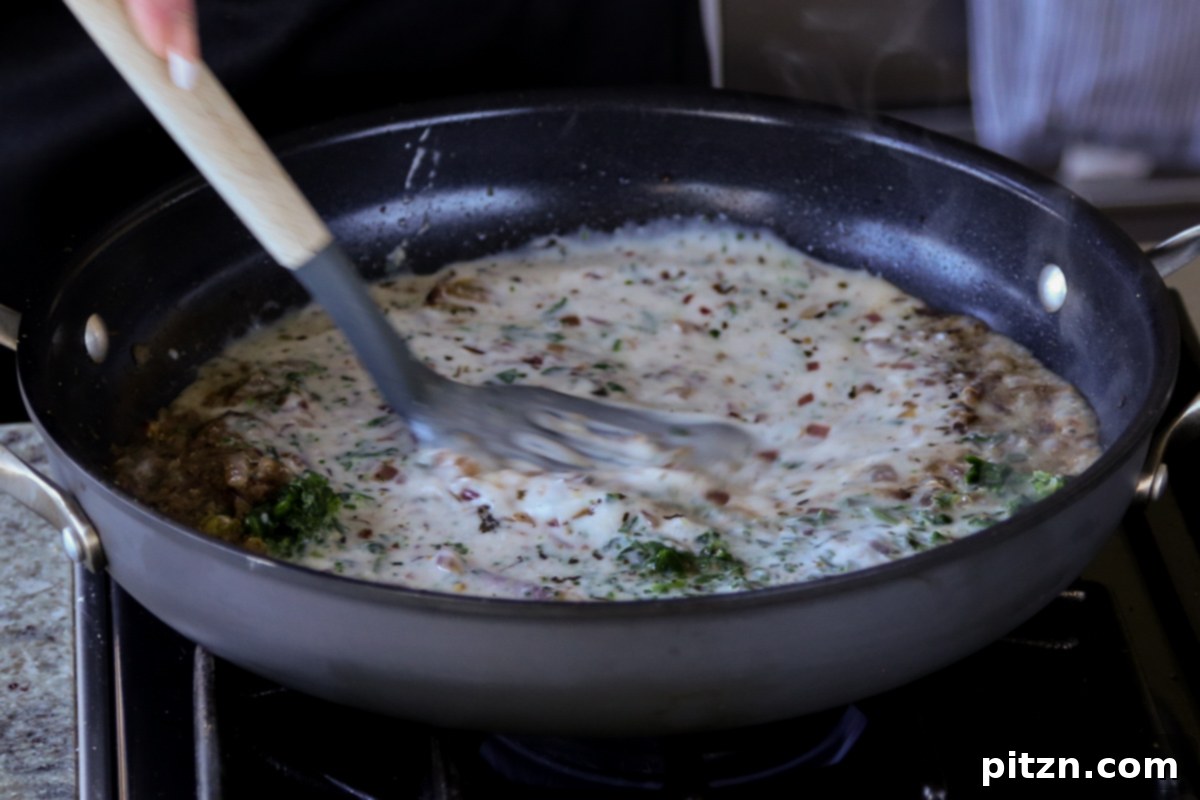 A close-up shot of the Kali Mirch sauce being stirred in the pan, showing its smooth, creamy consistency before adding beans.