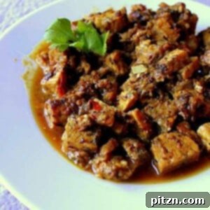 Fake chicken curry served on a white plate with a green garnish
