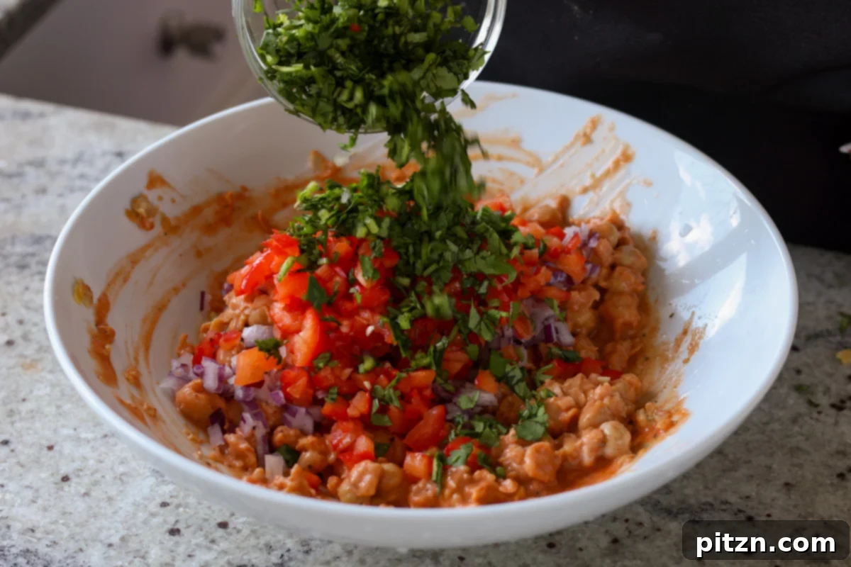 Gochujang Chickpea Sandwich with Sweet and Spicy Caramelized Onions 16 adding cilantro to the gochujang chickpea salad