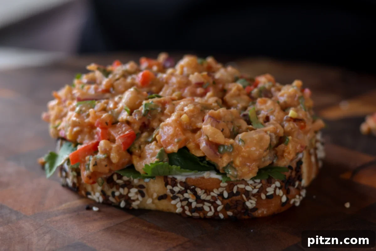 Gochujang Chickpea Sandwich with Sweet and Spicy Caramelized Onions 19 topping the cilantro on the bread with gochujang chickpea salad