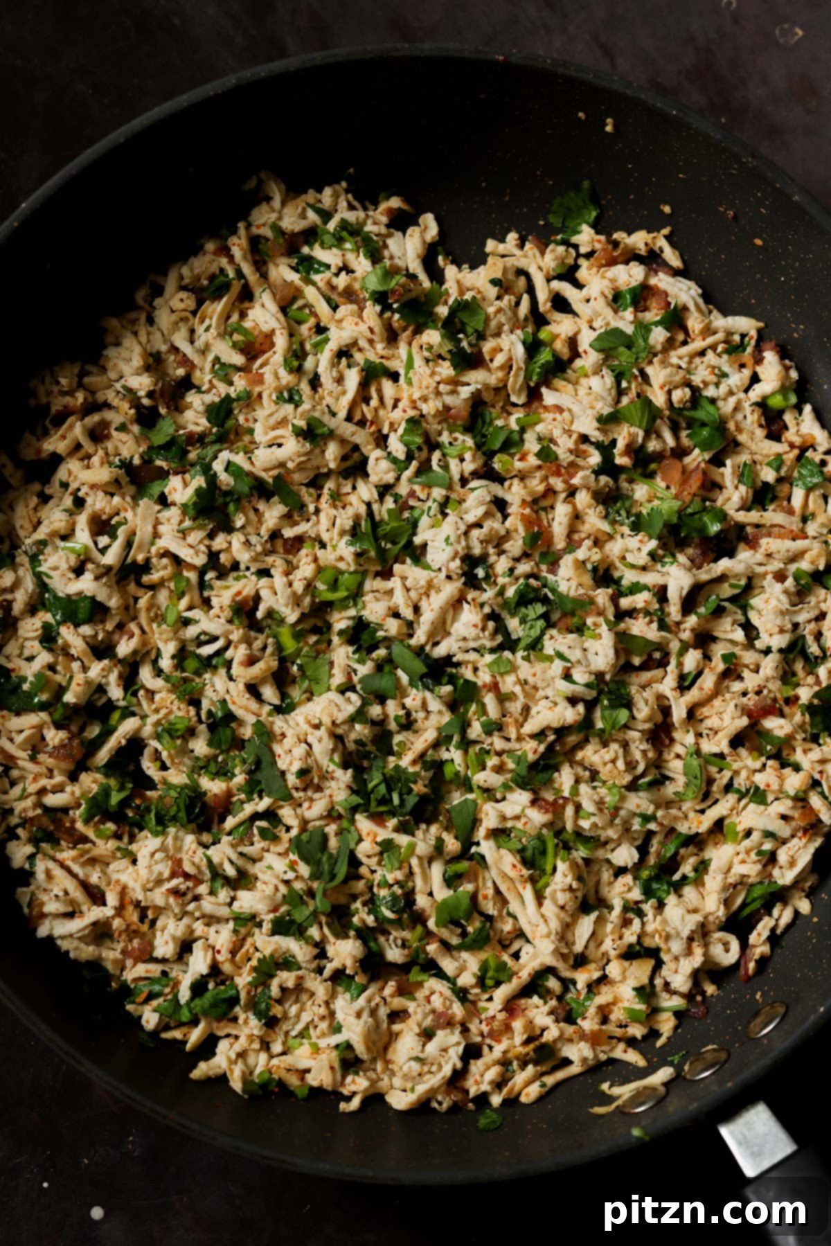 Cilantro lime shredded tofu cooking in a pan, showcasing its delightful texture after preparation.
