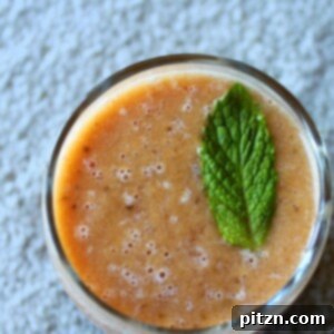 A top down shot of a mango strawberry mint cooler, garnished with a mint leaf, ready to be served