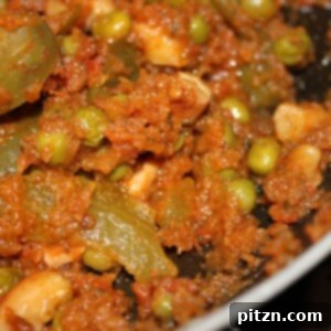 A close-up of a rich, red tomato cilantro curry, showcasing its inviting texture and warmth.