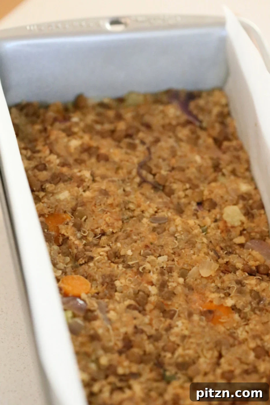 Tightly packing the lentil quinoa mixture into a loaf pan
