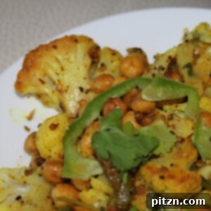 Zesty Achari Cauliflower with Chickpeas and Bell Peppers 2 A close up of Achari Gobi on a white plate